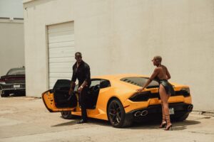 Male model Emanuel Jones, Jr. photographed with a female model and yellow Lamborghini.